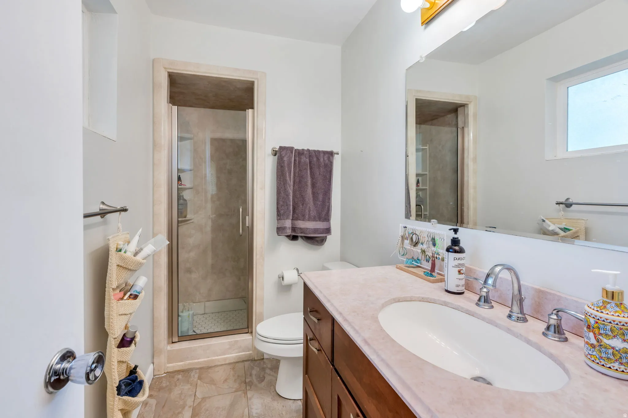 Spa-inspired primary bathroom featuring dual vanities with pink quartz countertops, an oval vessel sink, and polished chrome fixtures