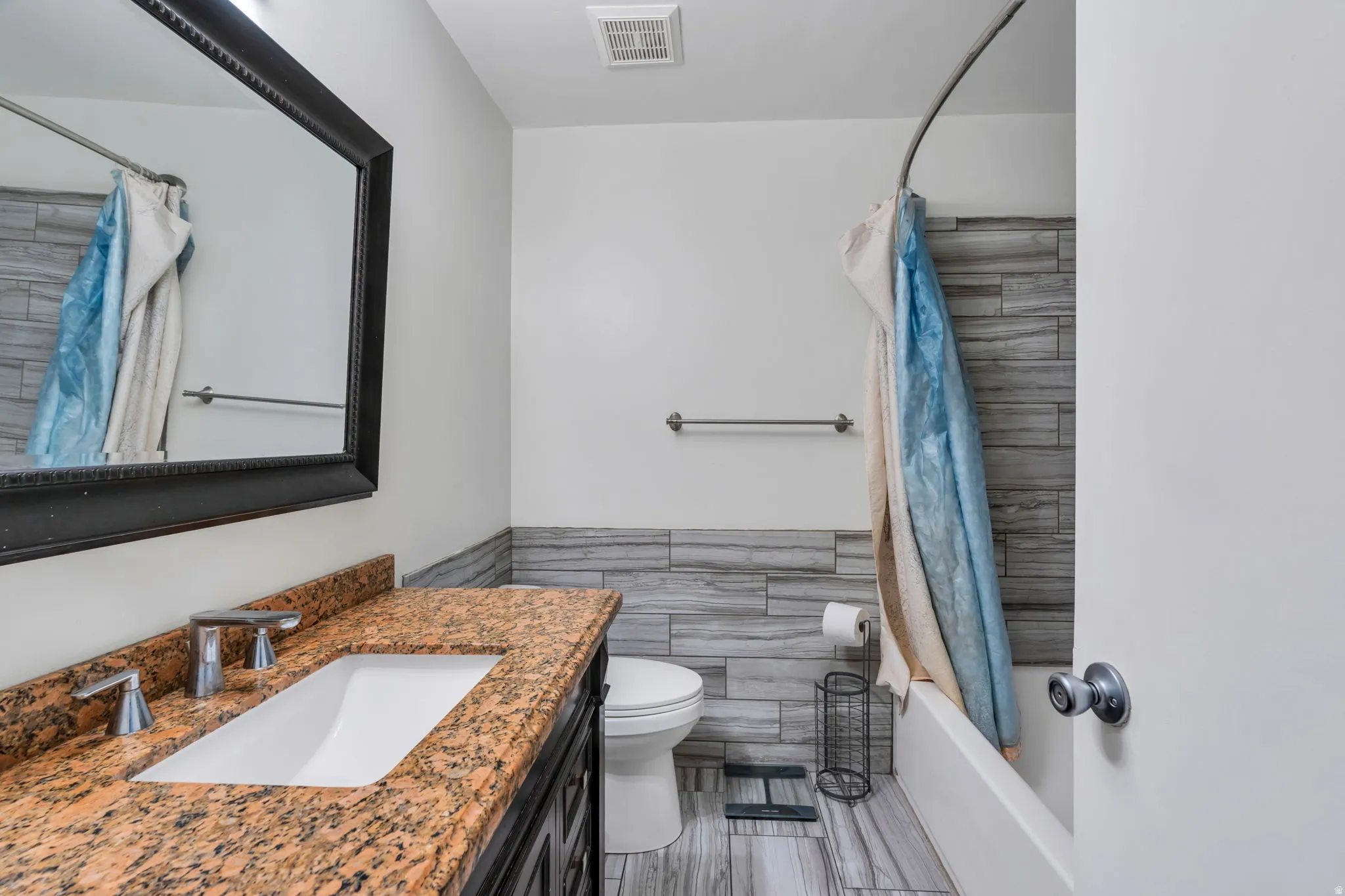 Modern vanity with a rectangular undermount sink and a speckled countertop