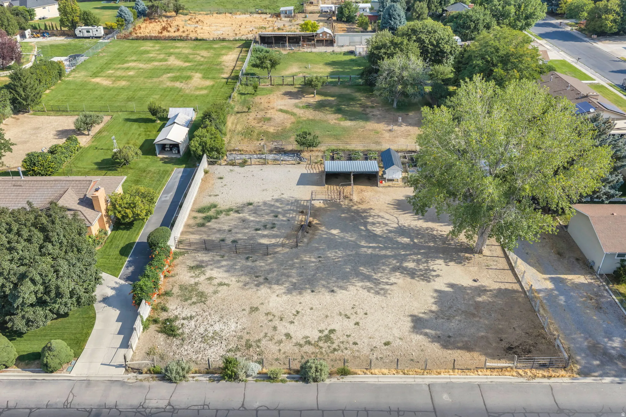 Expansive grounds featuring mature trees, open pasture areas, and established fencing