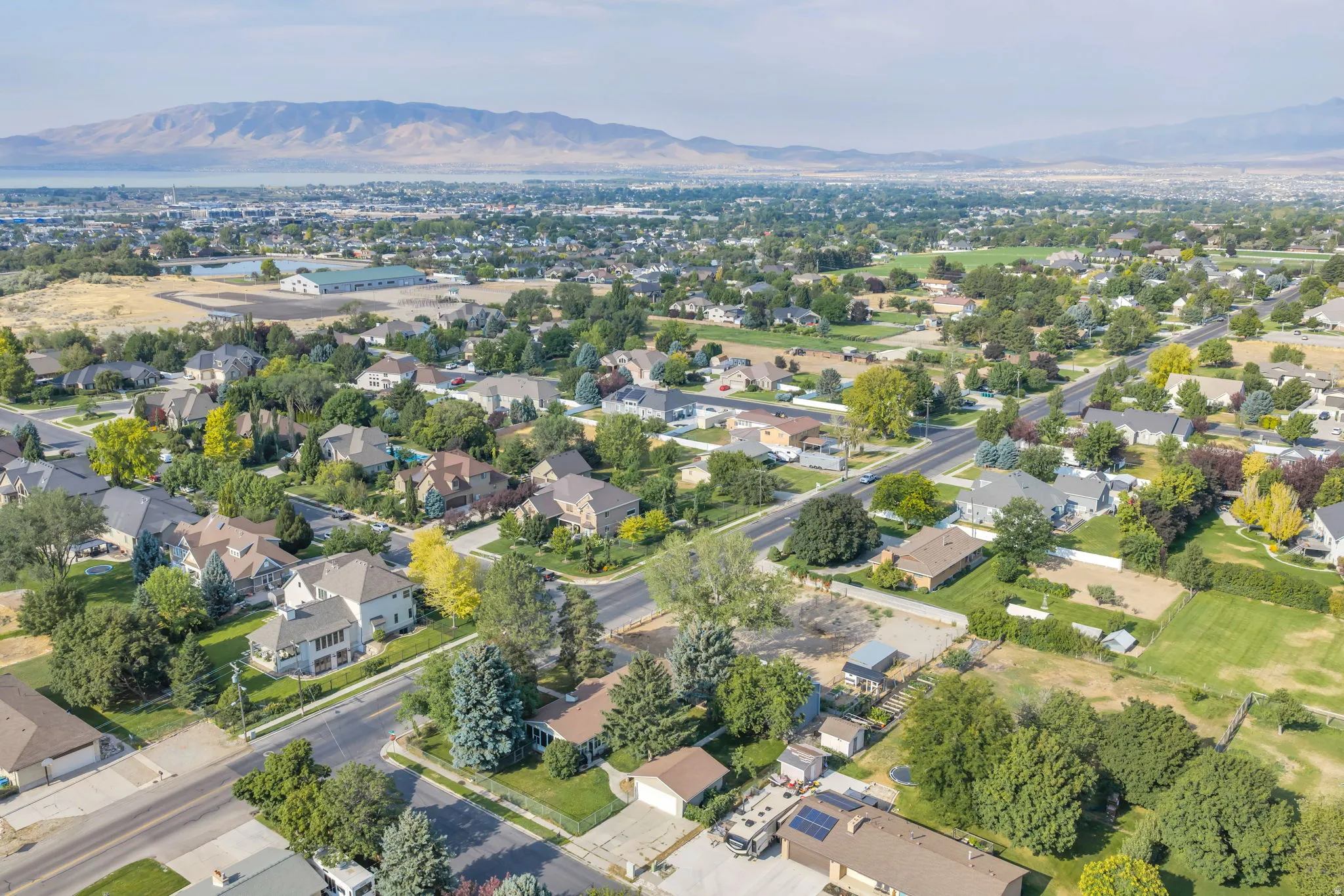 Aerial view showcasing this suburban property situated on a tree-lined street within an established residential community