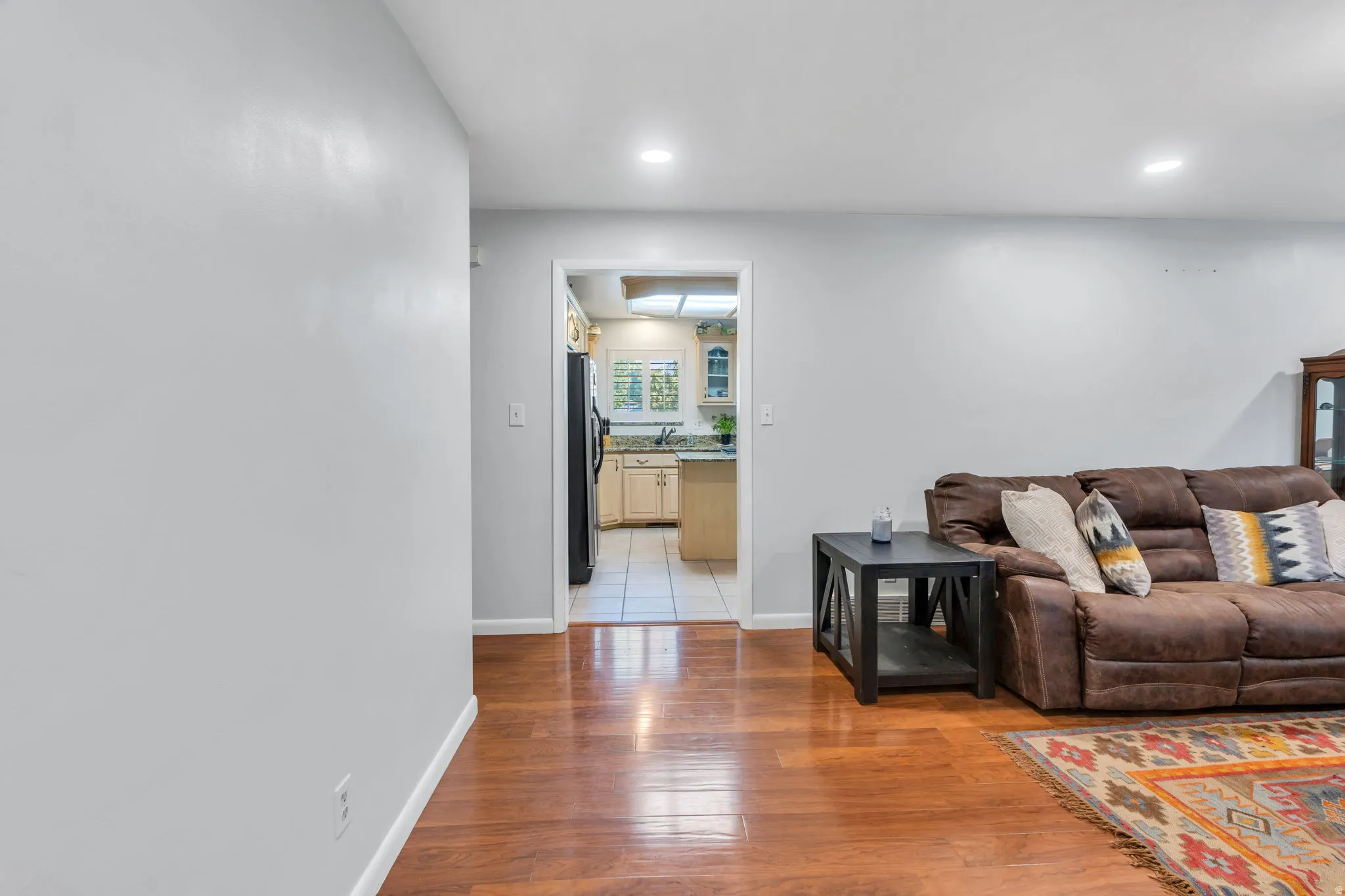 Wood-finish flooring, recessed lighting, and a neutral wall color