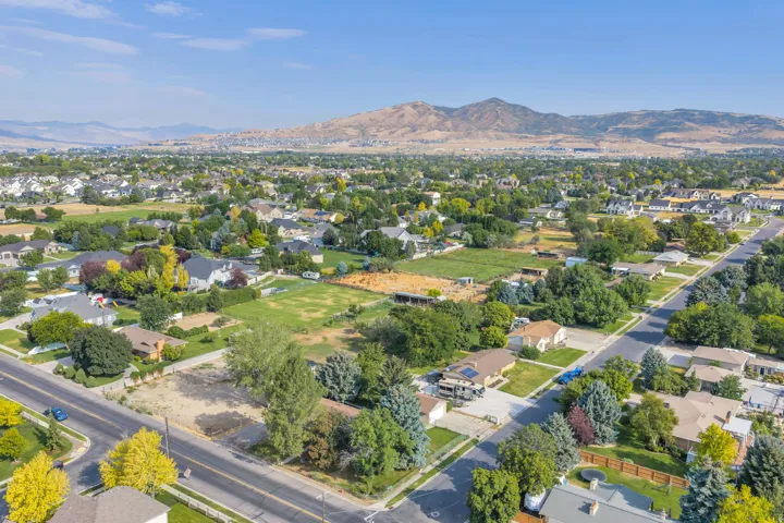 Aerial perspective showcasing a residential area with established landscaping and mountain scenery