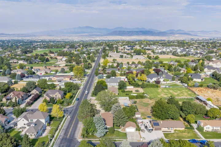 Expansive residential area featuring numerous single-family homes, mature trees, and a paved road network