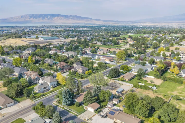 Aerial view showcasing this suburban property situated on a tree-lined street within an established residential community