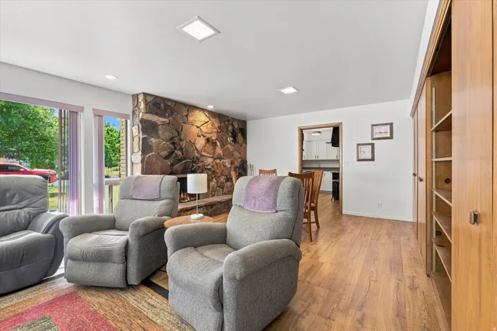 Wood-finish flooring, recessed lighting, and a stone-clad fireplace
