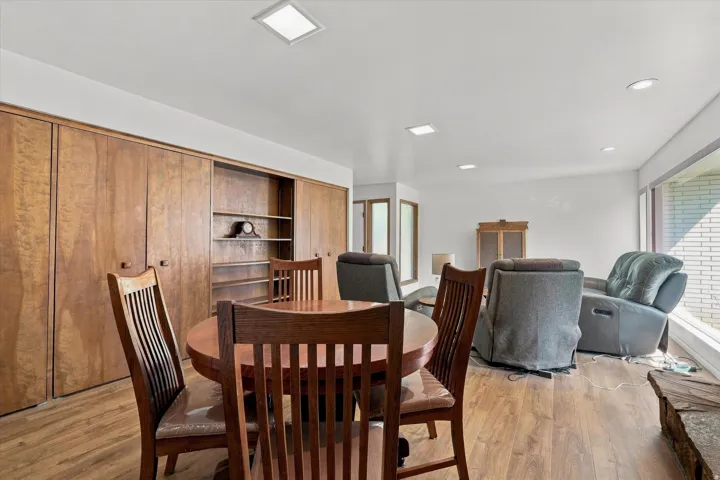 Wood-finish flooring, built-in shelving, expansive windows, recessed lighting, and square ceiling light fixtures