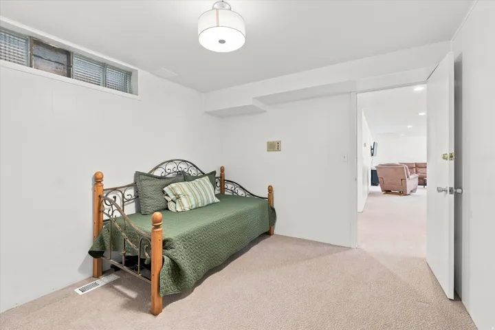 Spacious secondary bedroom featuring neutral carpeting, a high ceiling with recessed lighting, and direct access to an ensuite bathroom