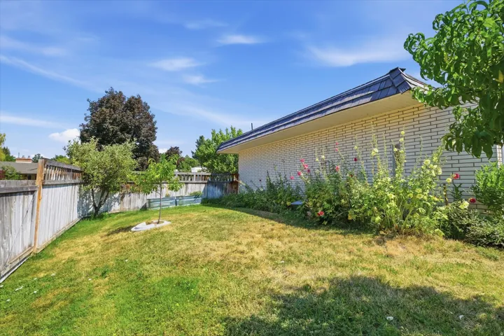 Expansive backyard with mature landscaping, manicured lawn, and established trees