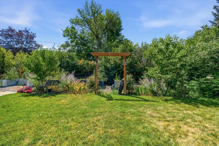 Expansive manicured lawn with mature landscaping and shade trees