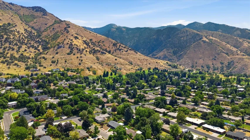 Established residential neighborhood nestled against scenic mountain foothills, featuring tree-lined streets, mature landscaping throughout the community, and abundant green space