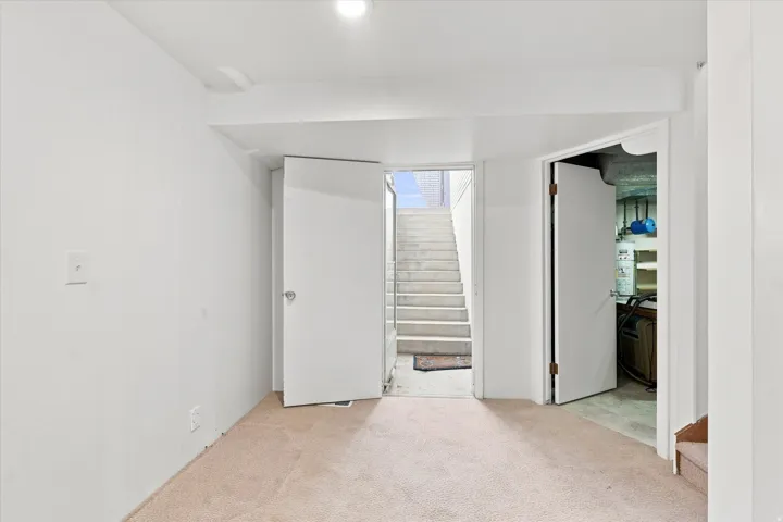 Bright basement space with neutral carpeting, white finished walls, and recessed ceiling lighting