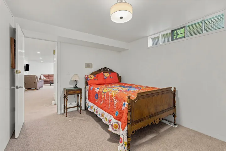 White walls, recessed lighting, and a neutral carpeted floor