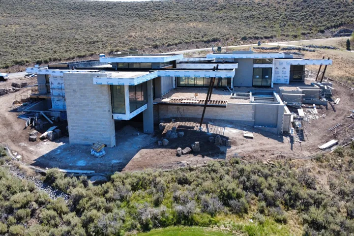 Modern architectural residence featuring clean-lined geometric forms with mixed material exterior combining stone and metal cladding