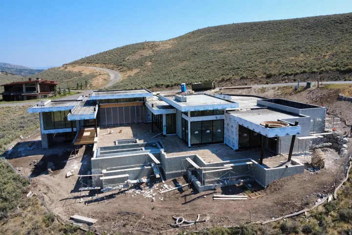 Modern architectural design featuring expansive glass panels and multi-level foundational elements