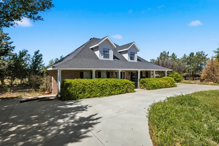 Charming residence featuring a distinctive peaked roofline with dormer windows, complemented by a covered front porch with multiple columns