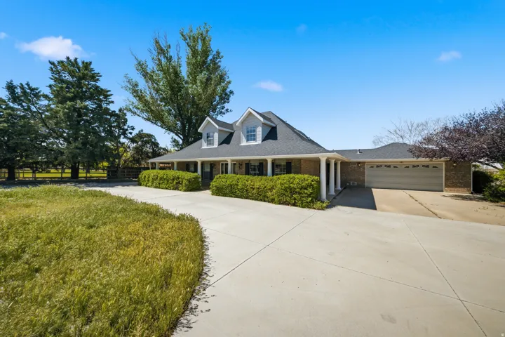 Brick exterior with a covered front porch, white columns, and dormer windows