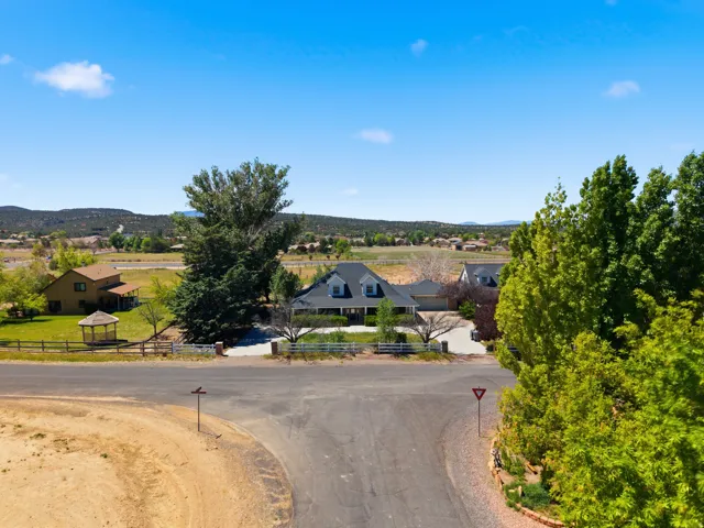 Striking residence set on expansive grounds with mature landscaping, including towering evergreens and established shade trees