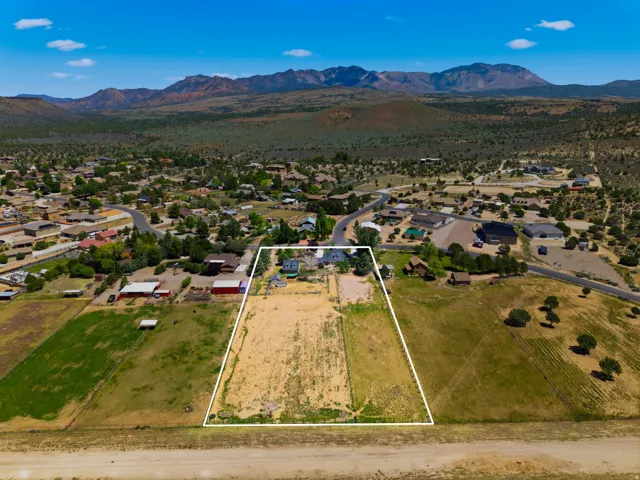 Expansive lot with adjacent residential properties, surrounded by natural desert landscaping and distant mountains