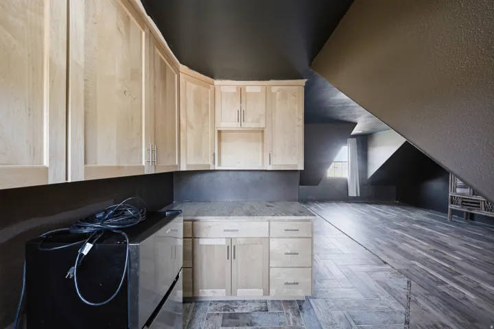 Light wood-finish cabinetry with silver-tone hardware, a light-toned countertop, and wood-finish flooring