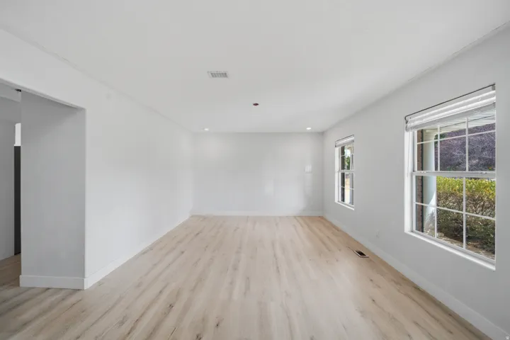 Recessed ceiling lighting, light wood-finish flooring, and two double-hung windows