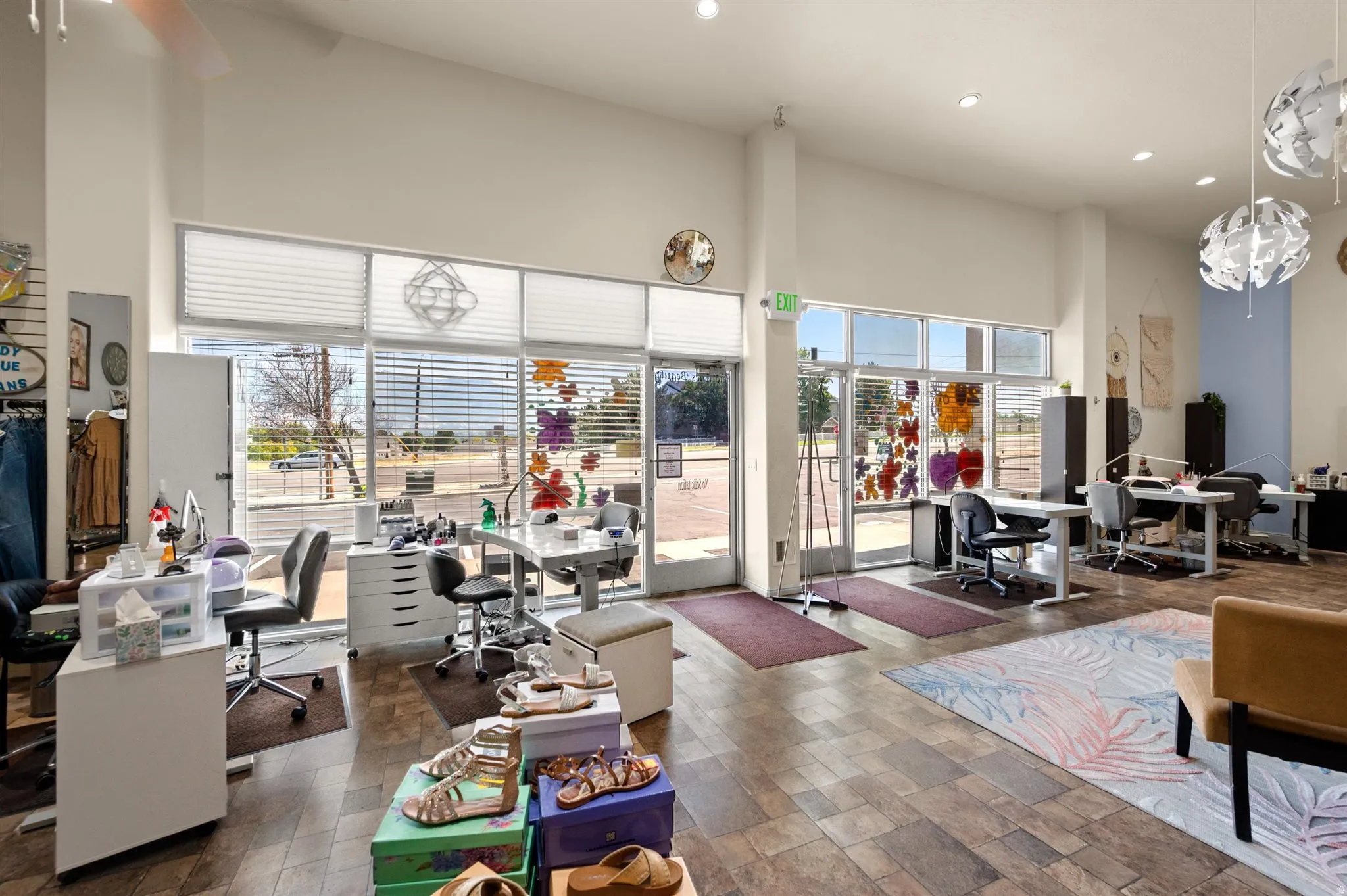 Spacious interior with high ceilings, multiple large windows with horizontal blinds,