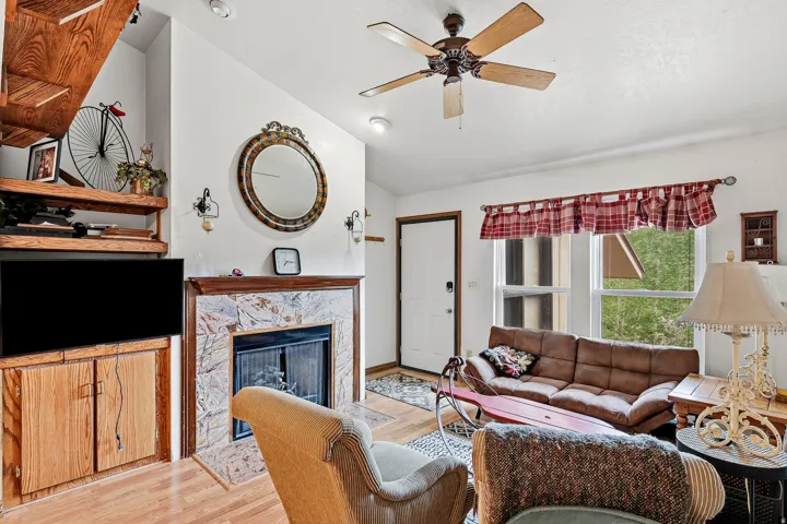 Living area with a fireplace featuring stone-finish tile, a wood mantel, and an integrated wood media cabinet
