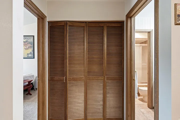 Louvered bifold doors with wood-finish trim
