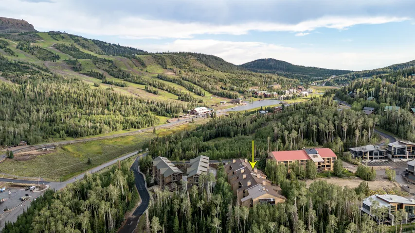 Multi-level building with pitched roofs situated among dense natural landscaping