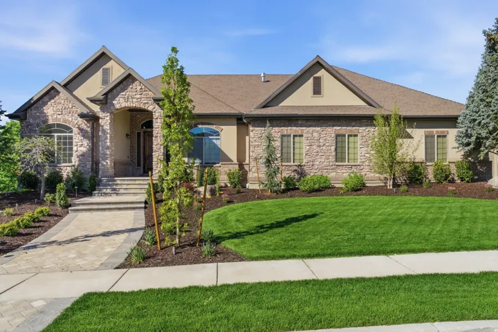 Stunning stone and stucco exterior with a covered entry portico and multi-gabled roofline