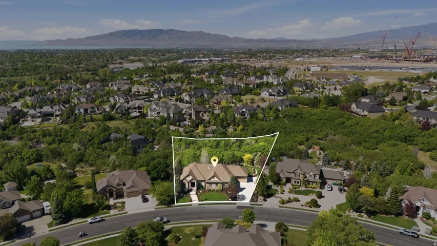 Expansive property set within a verdant, established neighborhood, featuring mountain scenery in the distance