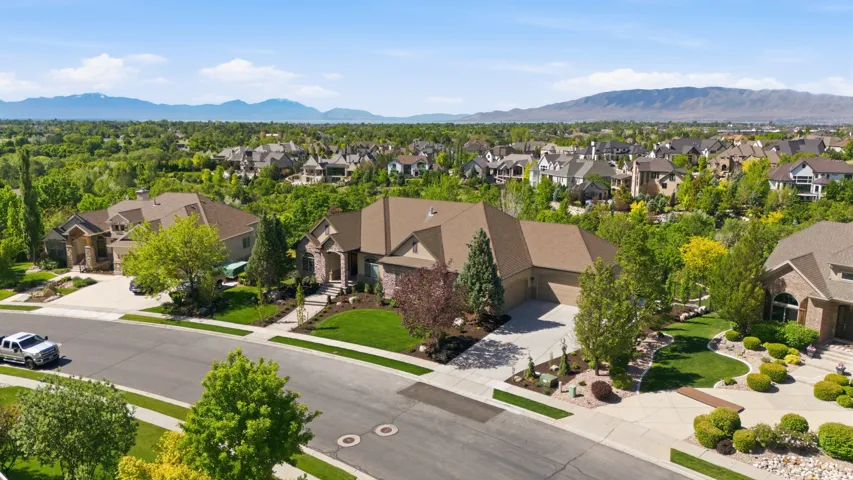 Expansive suburban neighborhood with mature trees and mountain scenery