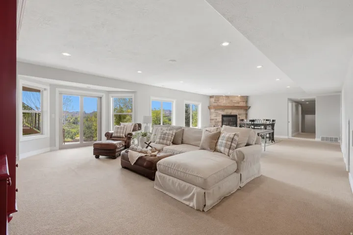 Expansive great room with soaring ceilings, recessed lighting, and abundant natural light from multiple large windows framing scenic vistas