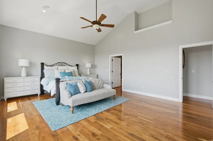 Vaulted ceiling with a ceiling fan, recessed lighting, and wood-finish flooring