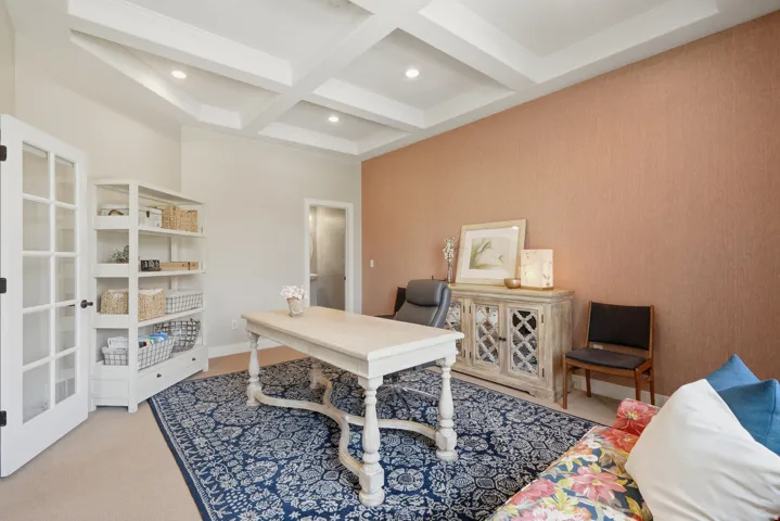 Coffered ceiling with recessed lighting, French doors, accent wall, and light-toned flooring