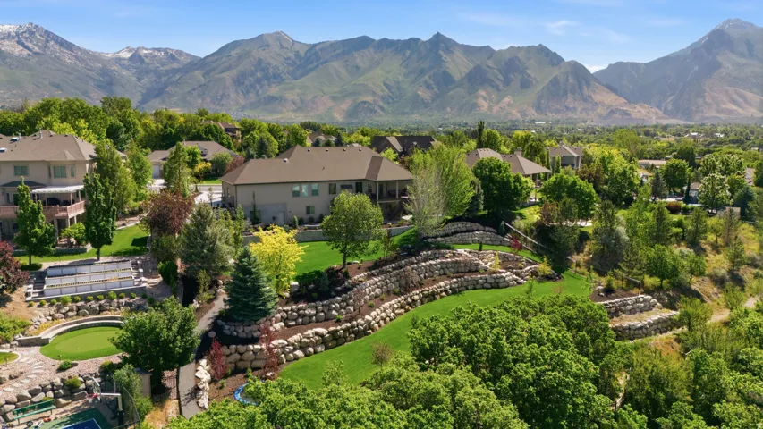 Stunning aerial view showcasing a luxurious estate nestled against dramatic mountain peaks