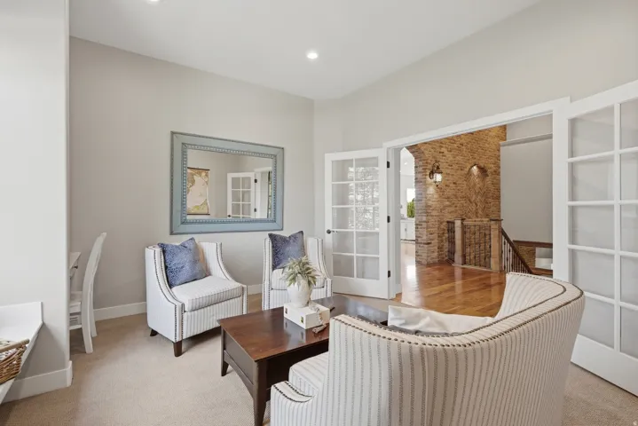 French doors with glass paneling, recessed lighting, carpeted flooring, wood-finish flooring, and a stone accent wall