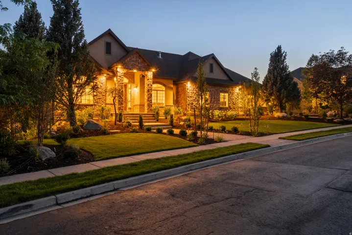 Elegant stone and stucco exterior with architectural gable detailing and dark asphalt shingle roofing
