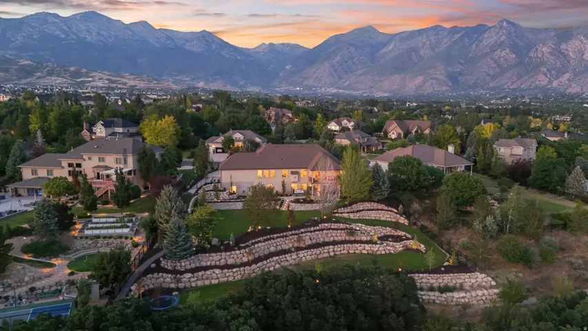 Expansive property with multi-level terraced landscaping, a large in-ground swimming pool, and a tennis court