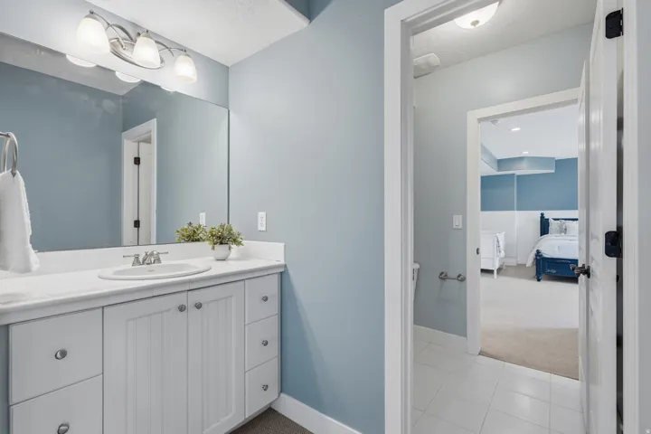 Spa-inspired primary bathroom featuring a white shaker-style vanity with dual sinks, polished chrome hardware, and a white quartz countertop