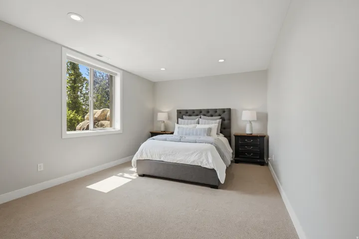 Recessed ceiling lighting, carpeted flooring, and a large window with white trim