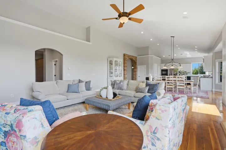 Open-concept living space featuring hardwood flooring, recessed ceiling lighting, and a wood-finish ceiling fan