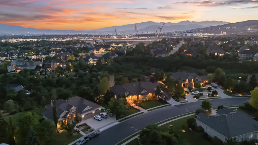 Twilight aerial showcasing an elegant estate nestled within mature landscaping and lush grounds