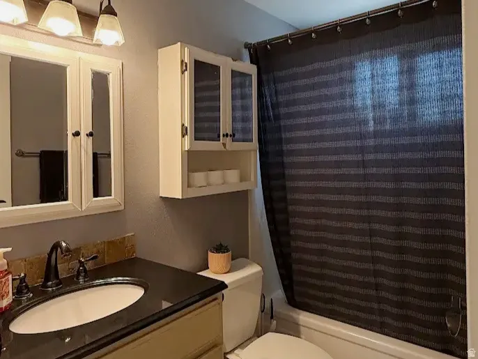 Vanity with dark countertop, undermount sink, and dark bronze faucet