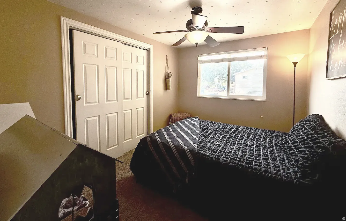 Recessed window with white blinds, ceiling fan with integrated lighting, and carpeted flooring
