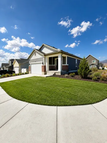 Contemporary residence featuring a covered entry, attached garage, and a concrete driveway