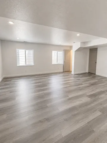 Recessed lighting, light gray wood-finish flooring, and white walls