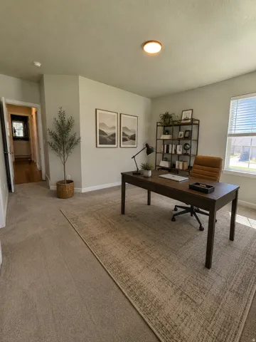 Sophisticated home office featuring a spacious layout with neutral wall finishes, recessed ceiling lighting, and large windows providing natural illumination