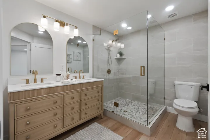 Dual arched mirrors above a vanity with double sinks and brass fixtures