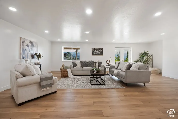 Recessed lighting, wood-finish flooring, white walls, and double French doors