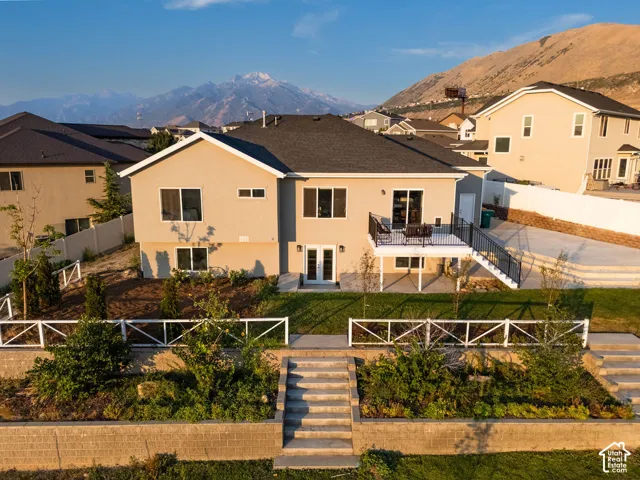 Two-story property with a stucco exterior and dark shingle roof